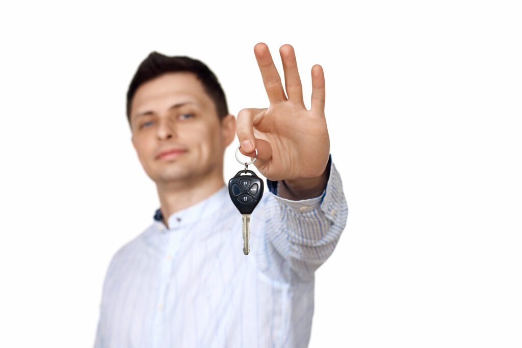 man holding car keys. Car dealerships offer car .